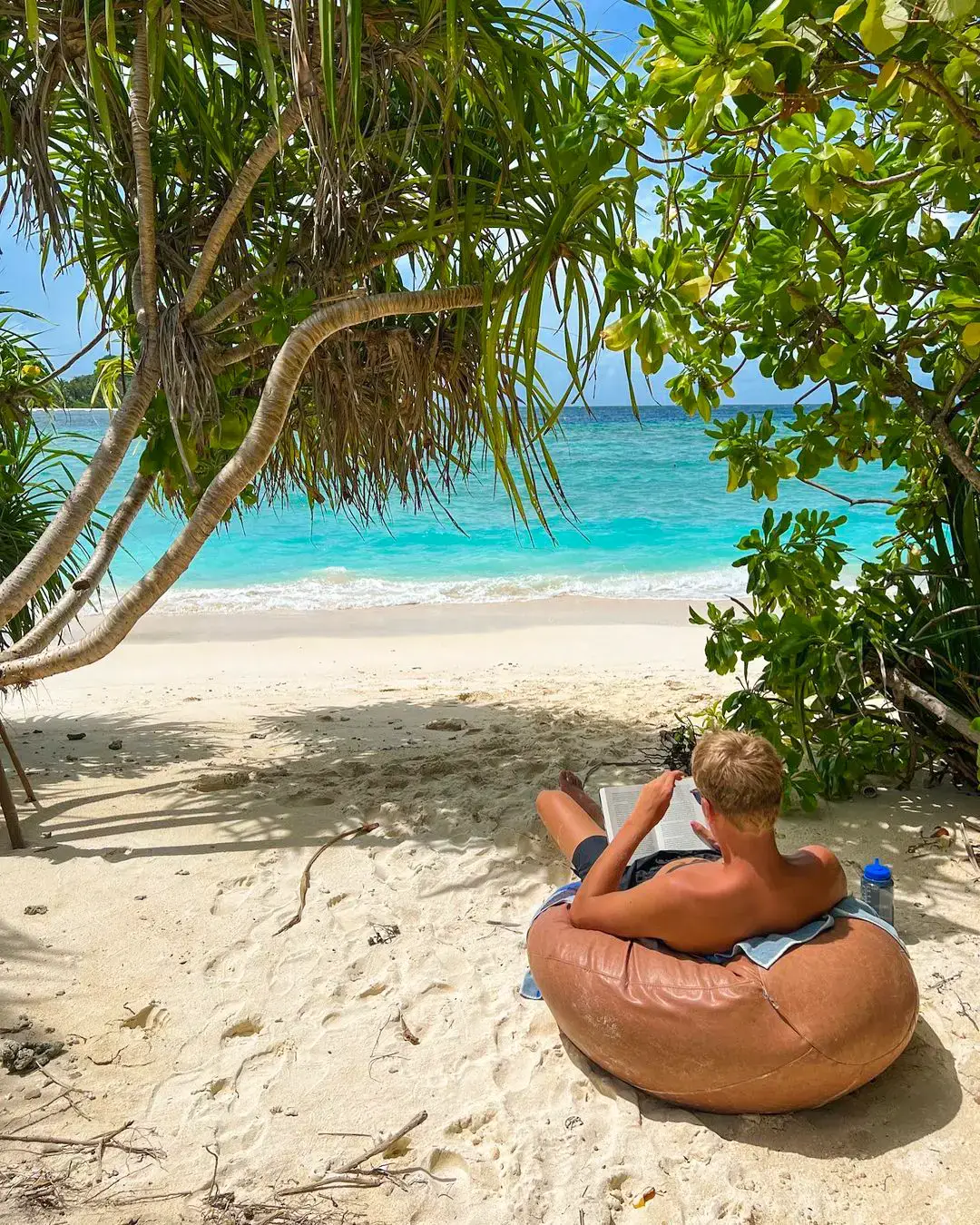 dreng er introvert og læser en bog på en strand